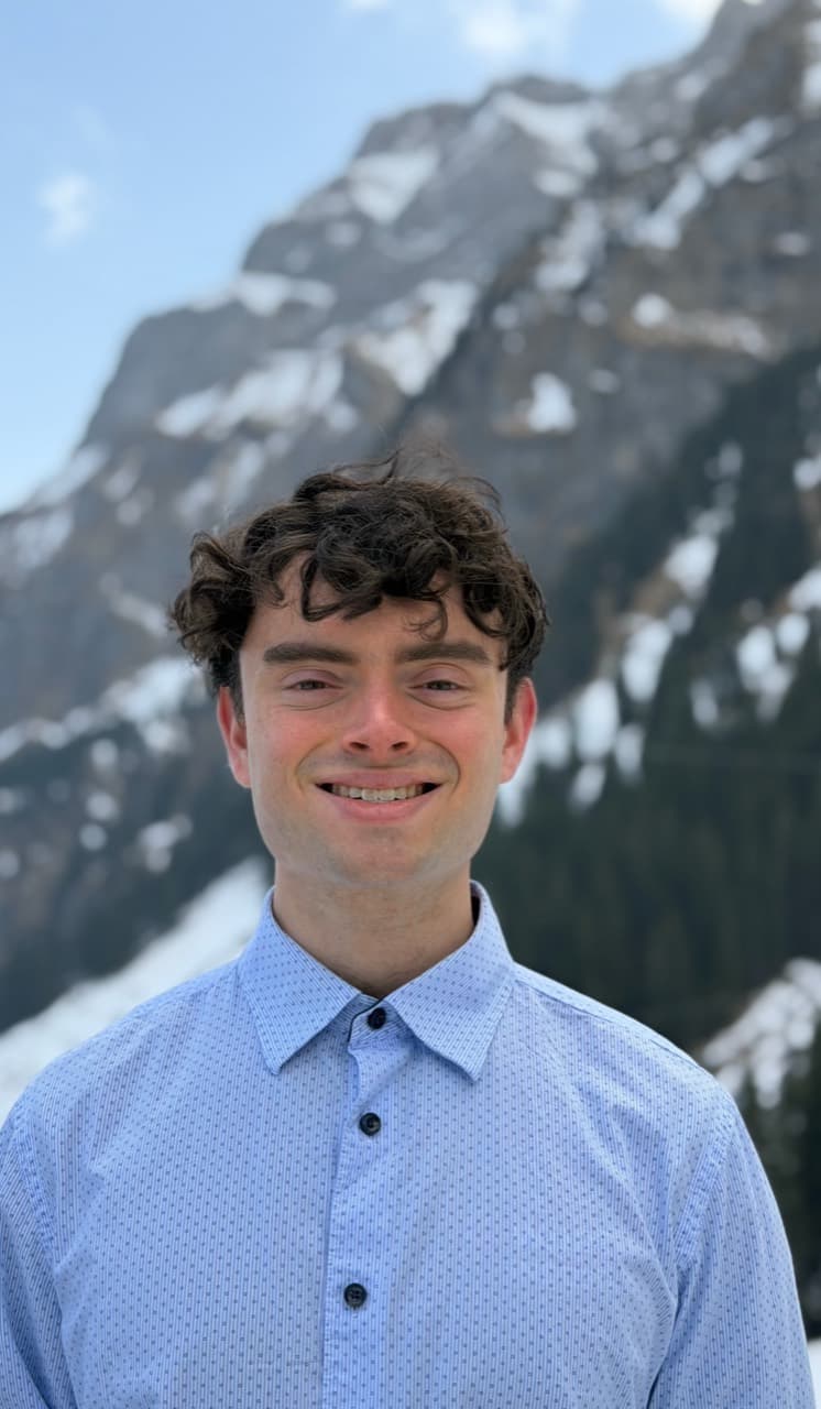 Alan standing outdoors in front of a mountain backdrop