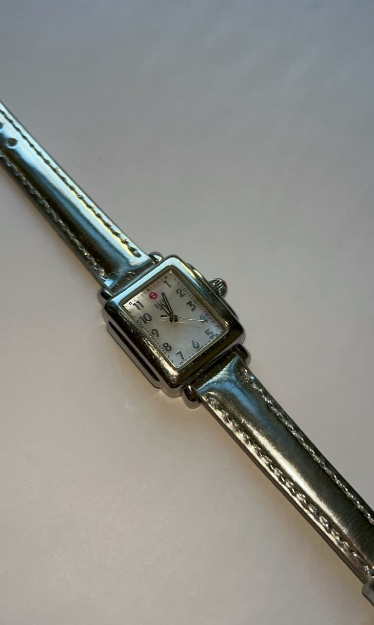 Square silver watch on a metallic strap
